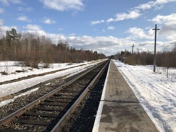 Snow covered railroad tracks against sky