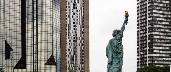 Low angle view of statue against buildings in city