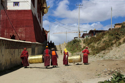 Rear view of people walking on street against buildings