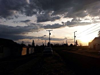 Electricity pylon against sky at sunset