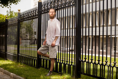 Full length of woman standing by fence