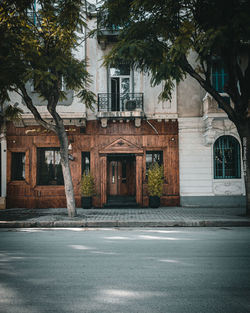 Empty road by buildings in city