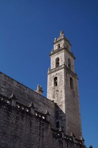 Low angle view of bell tower against blue sky