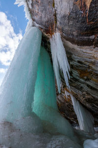 Panoramic shot of icicles on rock against sky
