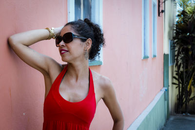 Portrait of a woman wearing red clothes on the street in bright sunny day. 
