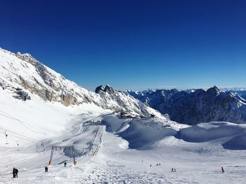 Scenic view of snowcapped mountains against clear blue sky