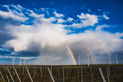 Scenic view of rainbow over field against sky