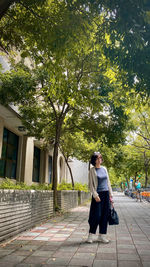 Rear view of woman standing against trees