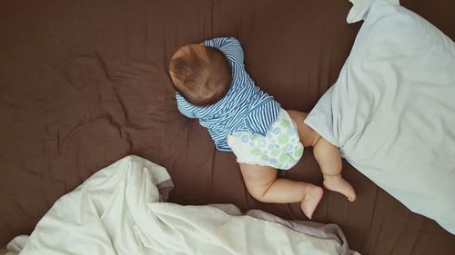 High angle view of baby boy lying on bed