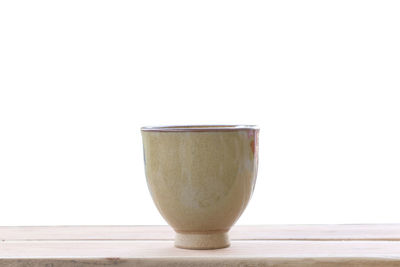 Close-up of beer glass on table against white background