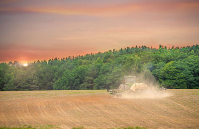 Scenic view of agricultural field against sky during sunset