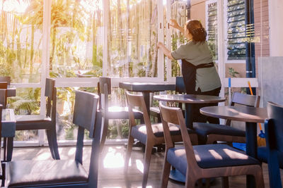 Woman standing on table in restaurant