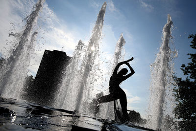 Water splashing in fountain against sky in city