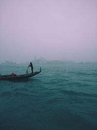 Man gondola boat on grand canal during foggy weather