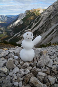 Sculpture on snow covered mountain against sky