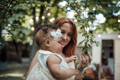 Portrait of mother and daughter against plants