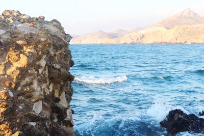 Scenic view of sea and mountains against sky