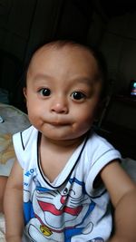 Portrait of cute baby girl sitting at home