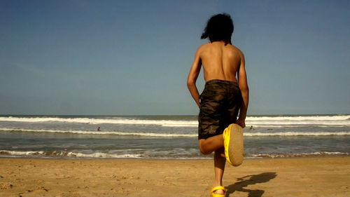 Rear view of man standing on beach