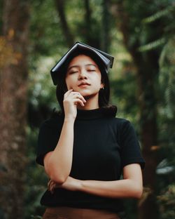 Young woman wearing hat standing in forest