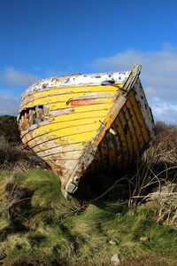 Abandoned boat against blue sky