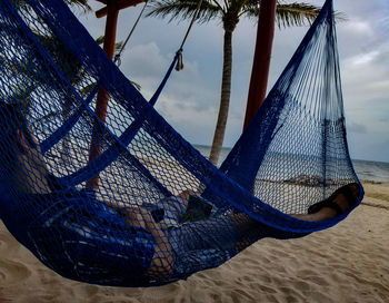 Low section of person on hammock at beach