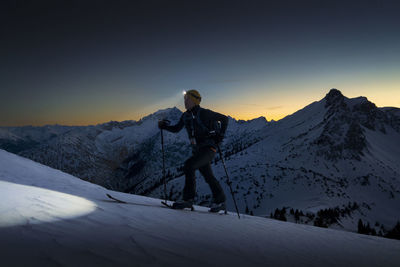 Man with headlamp walking on snowy mountain