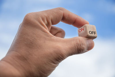 Low angle view of person hand against sky