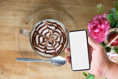 Hand holding coffee cup on table