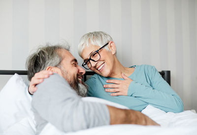 Senior couple romancing while lying on bed at home