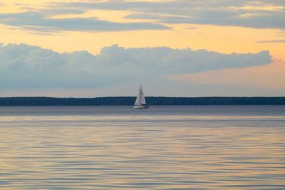 Boat sailing in sea at sunset