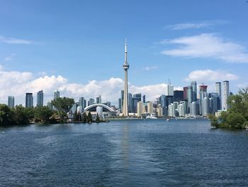 View of buildings at waterfront against cloudy sky