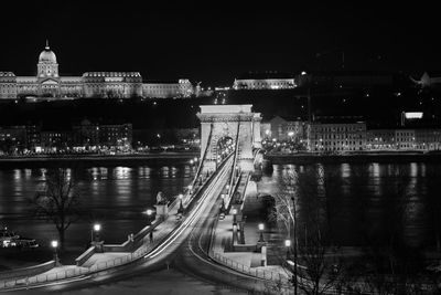 Illuminated bridge over river at night