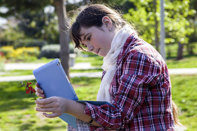 Girl photographing plant with digital tablet