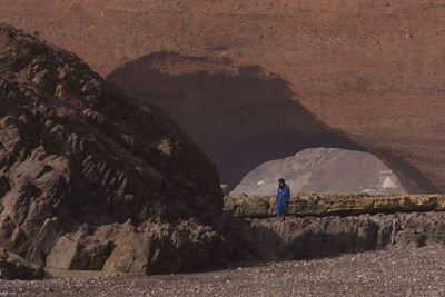 Man standing on rock by mountain