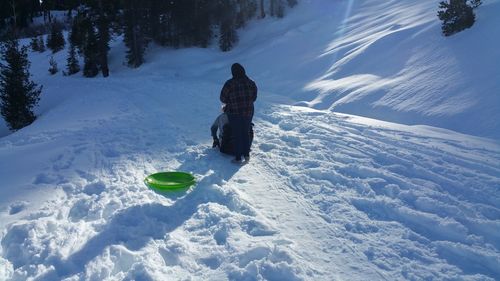 Rear view of person on snow covered field