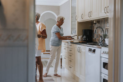 Smiling senior women preparing food in kitchen