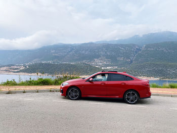 Red car on road against mountain range