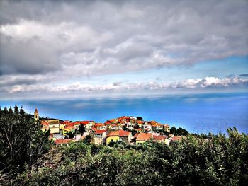 High angle view of townscape by sea against sky