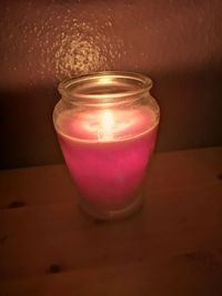 Close-up of lit candle in glass