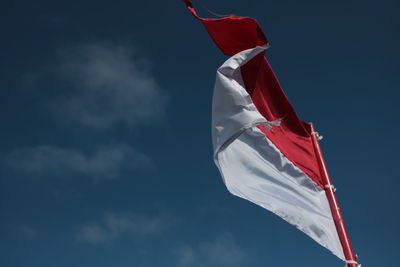 Low angle view of flag flags against sky