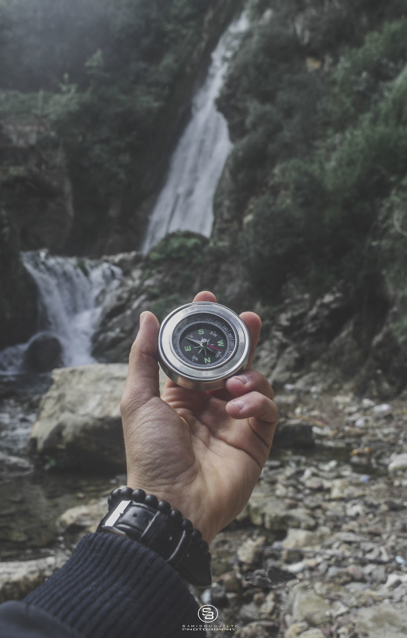 MIDSECTION OF MAN PHOTOGRAPHING WATER