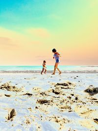 Full length of people on beach against sky