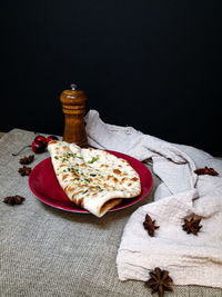 Close-up of pizza on table against black background