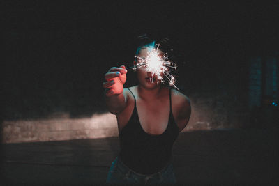 Woman holding illuminated light painting at night