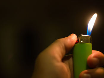 Close-up of hand holding candle against blurred background