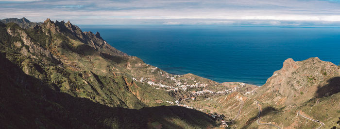 Scenic view of sea and mountains against sky