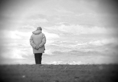 Rear view of woman standing against sky