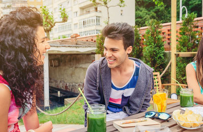 Smiling friends having food and drink at restaurant