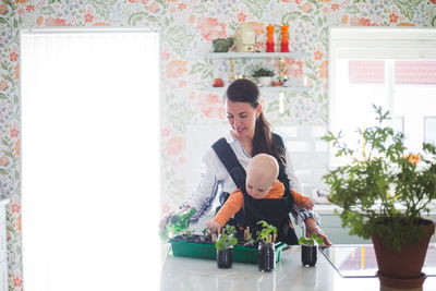 Working mother and daughter gardening in kitchen at home